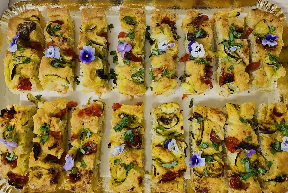 Plateau de focaccia garnie de légumes et de fleurs comestibles